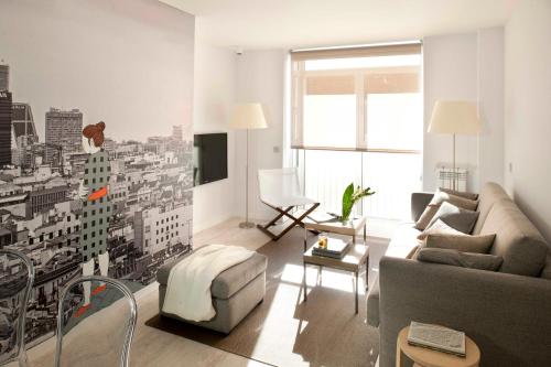 una sala de estar con un mural de la ciudad en la pared en Eric Vökel Boutique Apartments - Atocha Suites, en Madrid