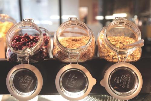 Tres recipientes de vidrio con comida sobre un mostrador con comida dentro. en Lapland Hotels Bear´s Lodge, en Sinettä