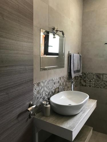 a bathroom with a white sink and a mirror at Panoraia Maisons in Margariti