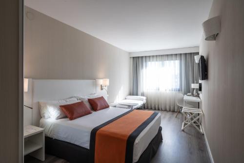 a hotel room with a large bed and a chair at Catalonia Sabadell in Sabadell