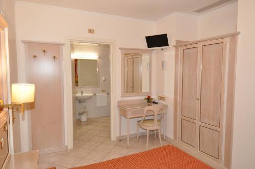 uma casa de banho com uma mesa, um lavatório e um WC. em Hotel Moderno em Stresa