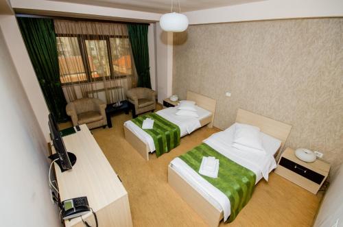a hotel room with two beds and a television at Hotel Davos in Deva