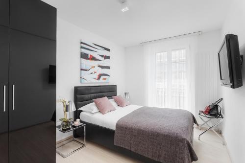 a bedroom with a bed and a flat screen tv at VISIONAPARTMENTS Cramerstrasse 2-6 - contactless check-in in Zürich