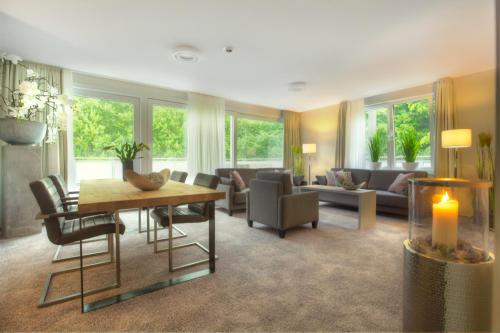 a living room with a couch and a table at Hotel des Nordens Flensburg Wellness & Spa in Flensburg