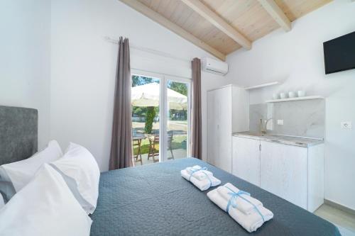 a bedroom with a bed with two towels on it at Studios Periklis in Prinos