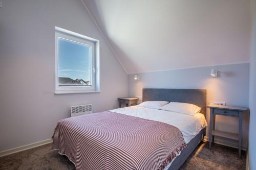 a small bedroom with a bed and a window at Domki Apartamentowe - Na Makowej in Jastrzębia Góra