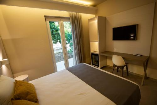 a hotel room with a bed and a desk and a television at Michelino House in Parghelia