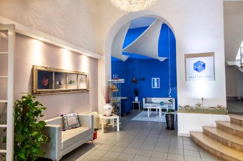 a living room with a blue wall and a couch at Hotel Meli in Castelsardo