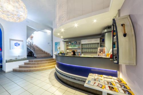 a restaurant with a counter and stairs in the background at Hotel Meli in Castelsardo