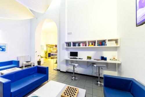 un soggiorno con divano blu e scrivania di Hotel Meli a Castelsardo