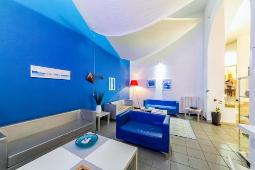 a living room with blue walls and a blue couch at Hotel Meli in Castelsardo