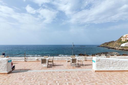 a patio with chairs and a view of the ocean at Hotel Meli in Castelsardo