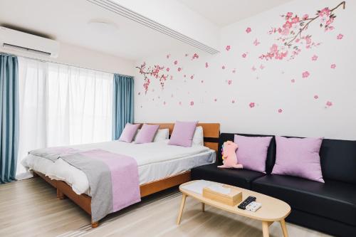 a bedroom with a bed and a couch with flowers on the wall at AFP Tennoji Apartment in Osaka