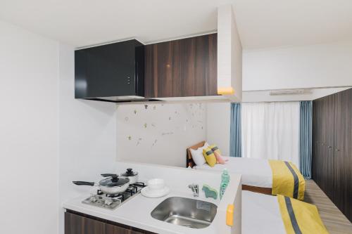 a kitchen with a sink and a bed in a room at AFP Tennoji Apartment in Osaka