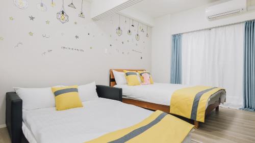 a bedroom with two beds and a window at AFP Tennoji Apartment in Osaka