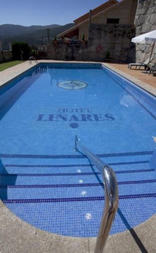 a blue swimming pool with a silver object in it at Hotel Liñares in Poio