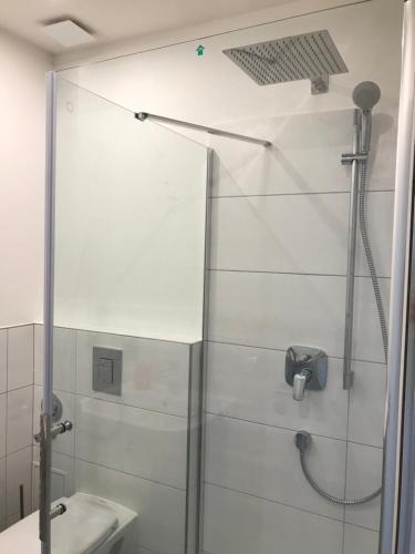 La salle de bains est pourvue d'une douche et d'un lavabo. dans l'établissement Apartmenthaus Hamburg Eppendorfer Weg, à Hambourg