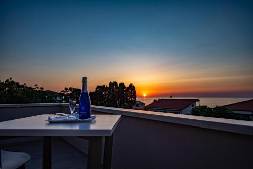 a bottle of wine sitting on a table with a glass at Michelino House in Parghelia