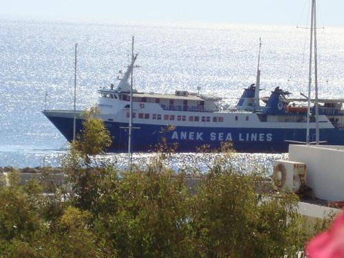 a large blue and white boat in the water at Stampalia Luxury Studios in Astypalaia Town
