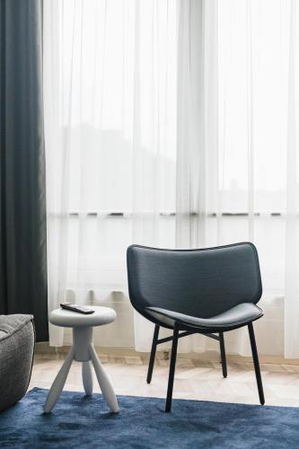 a chair and a stool in a living room at ROXI The Urban Residence Brussels in Brussels
