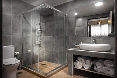 a bathroom with a shower and a sink at Pallada Athens boutique rooms & apartments in Athens