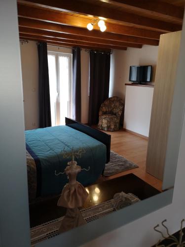 a bedroom with a bed and a chair and a window at CASA TITA in Lavacolhos