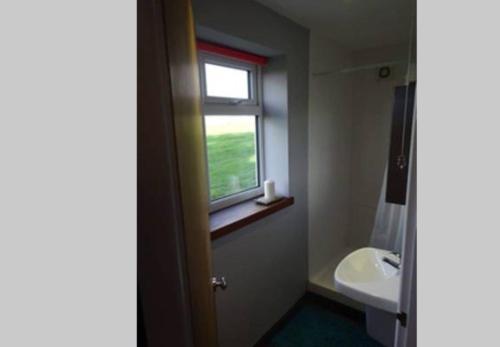 baño con lavabo y ventana en Little Trenoweth, en Saltash