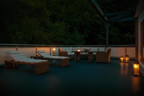 a patio with chairs and tables and candles on a deck at Hotel des Nordens Flensburg Wellness & Spa in Flensburg