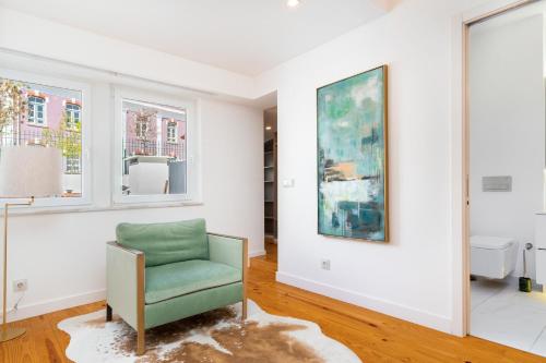 una sala de estar con una silla verde y una pintura en WHome | Combro Luxury Apartment, en Lisboa