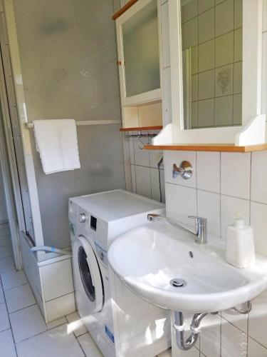 a bathroom with a sink and a washing machine at Ferienwohnung Mammut 1 in Salzgitter