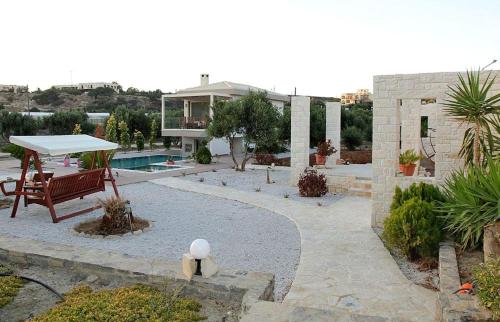 a house with a pool and a table and a bench at Villa Pelagos in Koutsounari