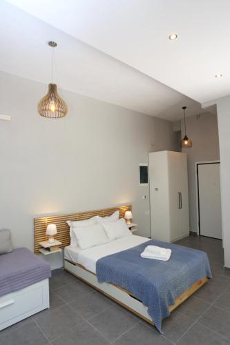 ein Schlafzimmer mit einem großen Bett und einer blauen Decke in der Unterkunft Polychrono Suite 2 in Polychrono