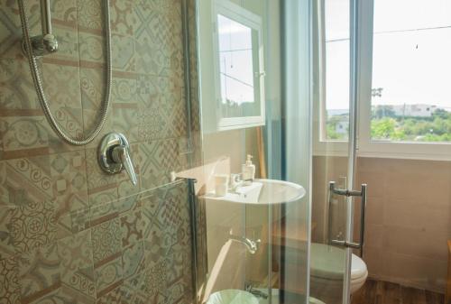 a bathroom with a shower and a sink and a toilet at La Bellavista Mola di Bari in Mola di Bari