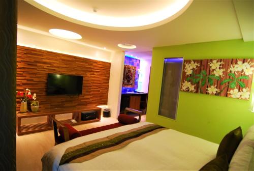 a hotel room with a bed and a tv at A&L Inn 戀灣旅棧 in Nanwan
