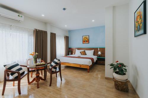 フーコックにあるCountryside Phu Quoc Resortのベッド、テーブル、椅子が備わるホテルルームです。