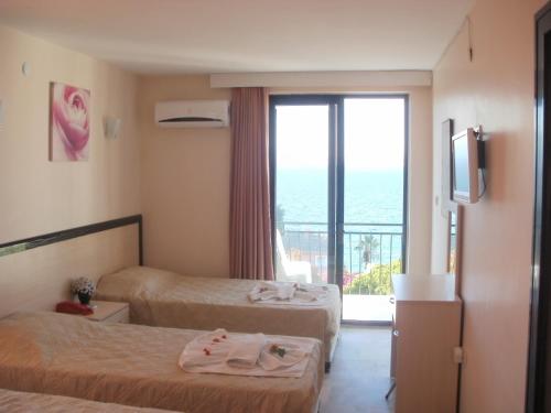 a hotel room with two beds and a window at Hotel Melike in Kuşadası