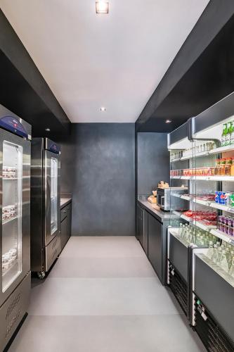 a kitchen with black walls and an open refrigerator at Hyatt Place Dubai Wasl District Residences in Dubai