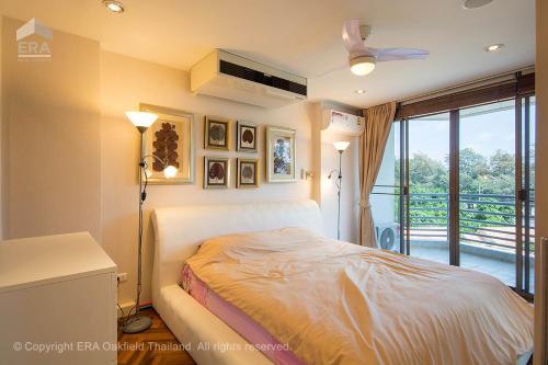 ein Schlafzimmer mit einem Bett und einem Balkon in der Unterkunft Rayong by Milanee in Ban Phe