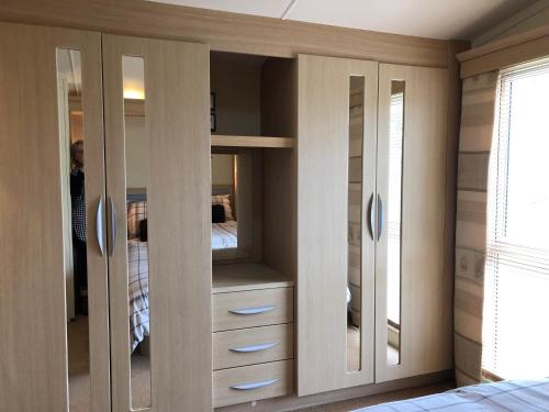 a bedroom with wooden cabinets and a bed at 28 Borwick Lakes in Carnforth