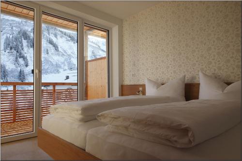 ein Schlafzimmer mit zwei Betten und einem großen Fenster in der Unterkunft Haus Margaritta Top 4 in Damüls