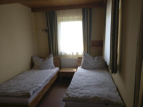 2 camas en una habitación pequeña con ventana en Ferienwohnung Strohmaier, en Kitzeck im Sausal