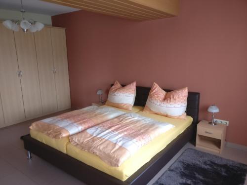 a bedroom with a large bed with pink walls at Ferienwohnung Strohmaier in Kitzeck im Sausal