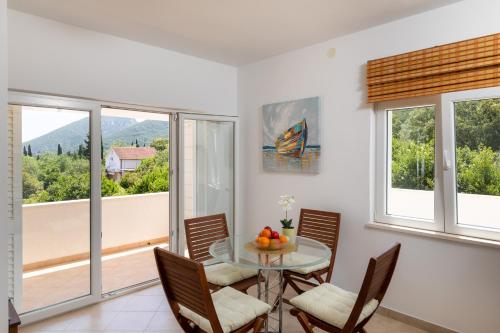 a dining room with a table and chairs and windows at Apartment Relax Ston in Ston