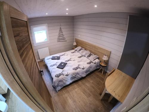 ein Schlafzimmer mit einem Bett in einem kleinen Zimmer in der Unterkunft Chalet de l'Oisans in Allemont
