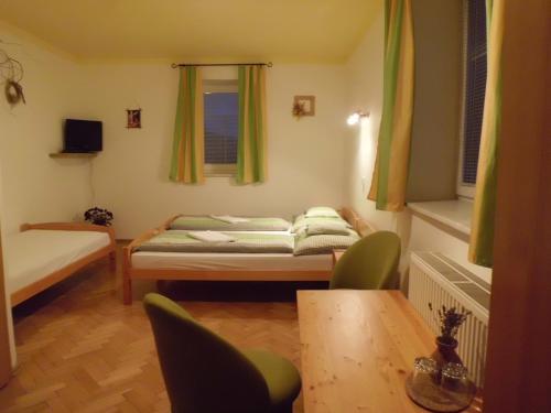 チェスキー・クルムロフにあるペンション マーテのベッド、テーブル、椅子が備わる小さな客室です。