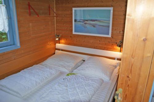 a small bed in a room with a picture on the wall at Blockhaus _ ideal bis 4 Personen in Damp