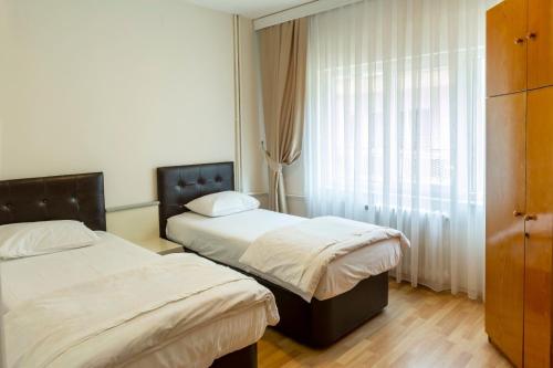 um quarto de hotel com duas camas e uma janela em Vip Apart Hotel em Bursa