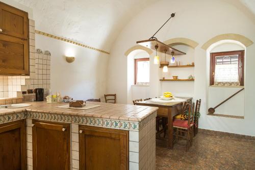 a kitchen with a counter top and a table at Umbra Idris Holiday Home in Matera