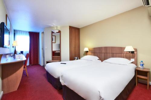 ein großes weißes Bett in einem Hotelzimmer in der Unterkunft Kyriad Genève St-Genis-Pouilly in Saint-Genis-Pouilly