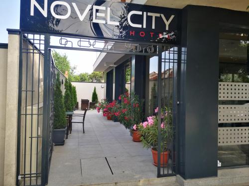 a walkway outside of a flower shop with potted plants at Family Hotel Novel City in Burgas